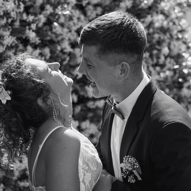Bride and groom laughing together on their wedding day, in black and white